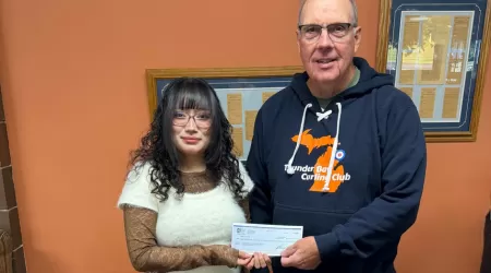 AAACU Team member presents a check to a member of the Cheboygan High School Senior Class of 2025